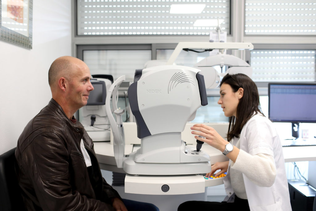 Ophtalmologue en consultation avec un patient avec son instrument de diagnostic