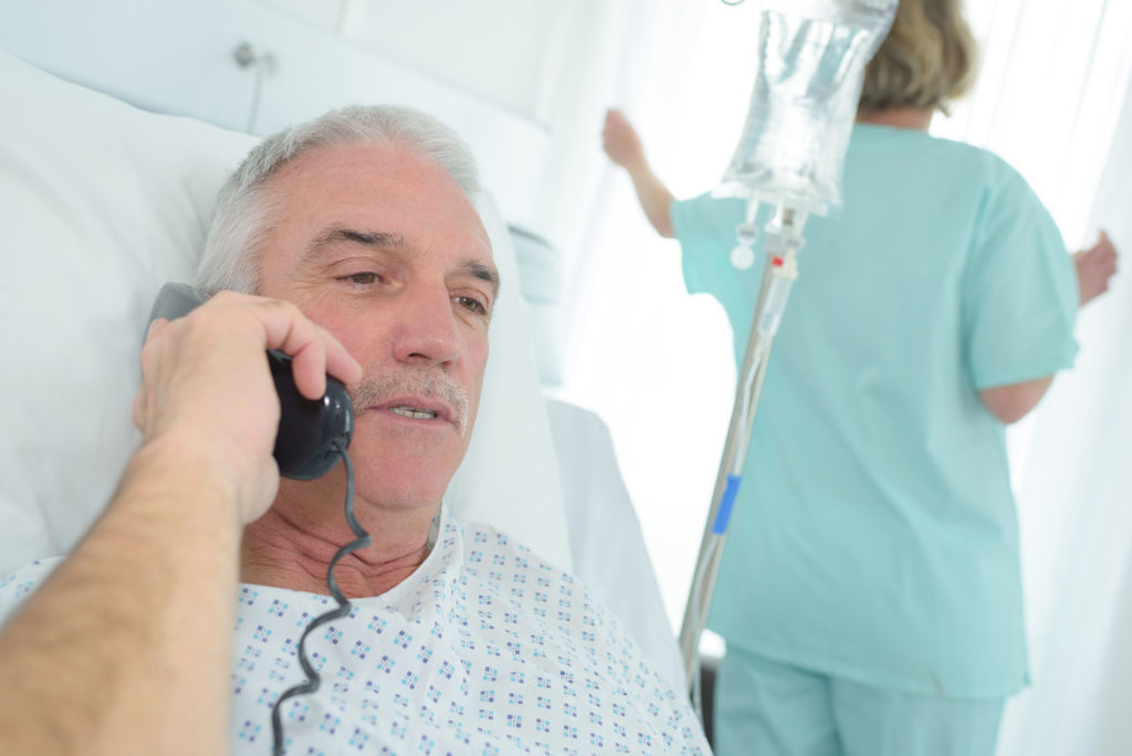 patient dans son lit d'hôpital qui passe un appel