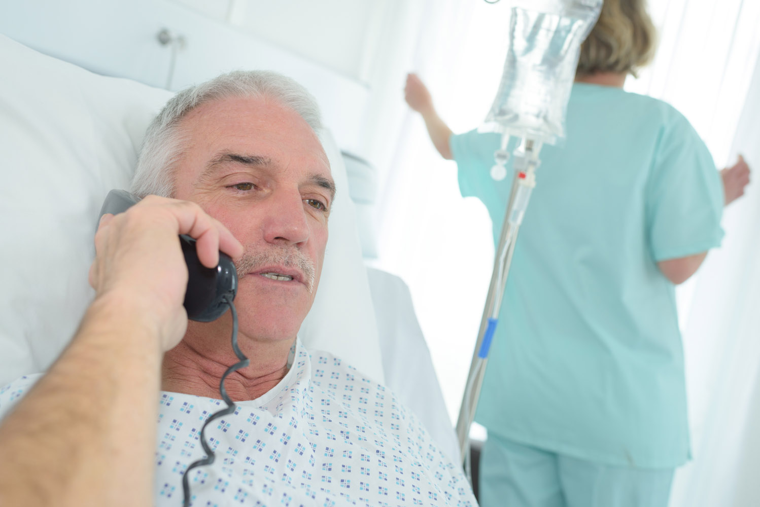 patient dans son lit d'hôpital qui passe un appel